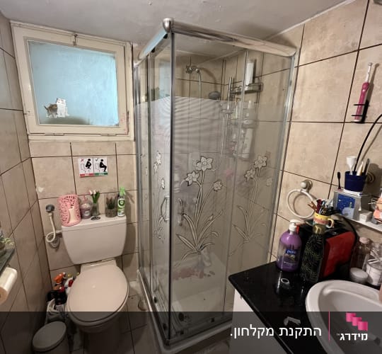 מקלחון זכוכית עם דלתות פרחוניות ומקלחת יד